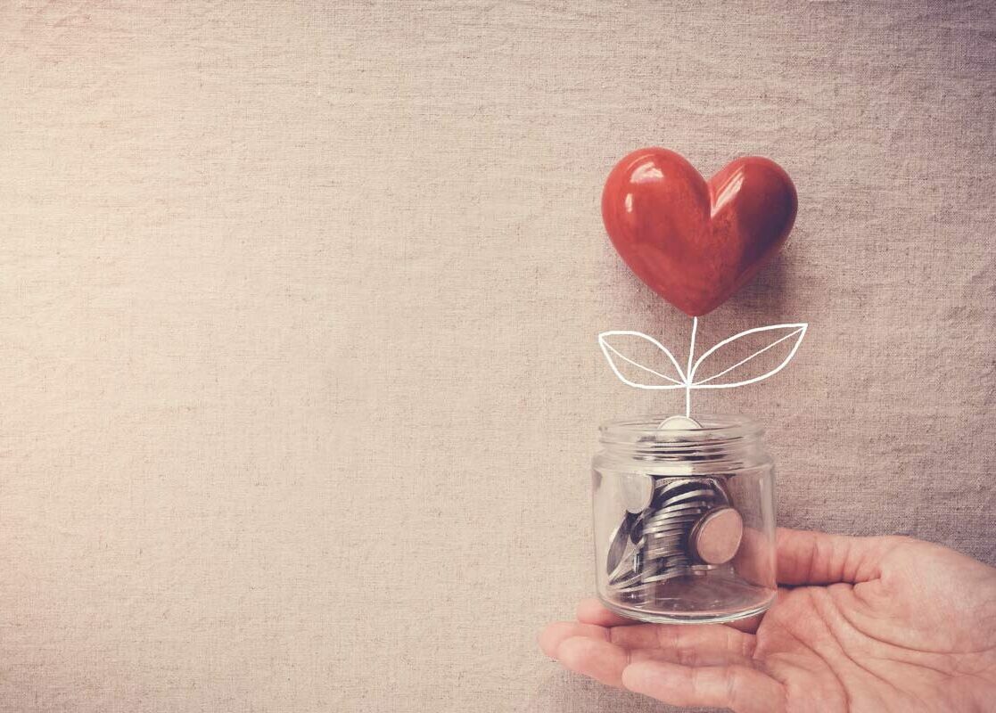 hand holding jar with coins and heart tree planned giving